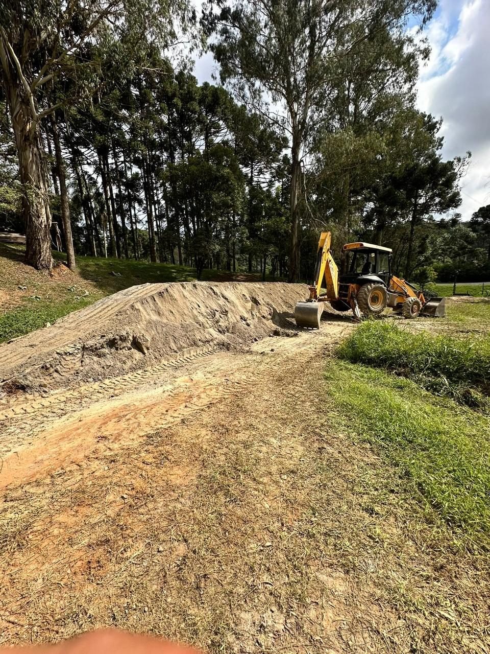 Retroescavadeira JCB fazendo corte e nivelamento de talude